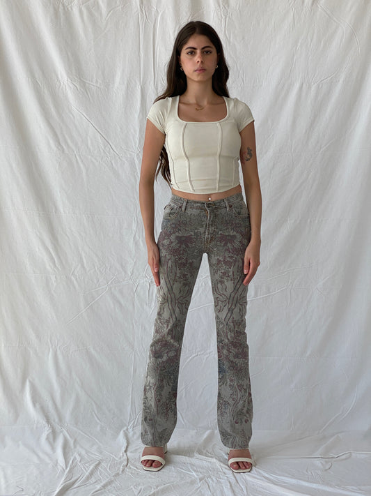 بنطلون جينز من Just Cavalli رمادي اللون بطبعة زهور وتفاصيل لامعة وقصّة واسعة