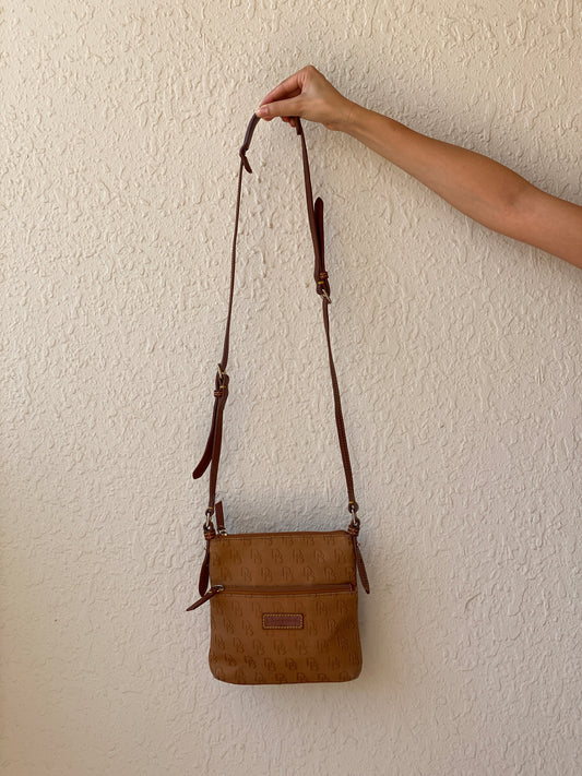 حقيبة كروس بودي Dooney & Bourke بنية اللون بشعار مونوغرام وحواف جلدية