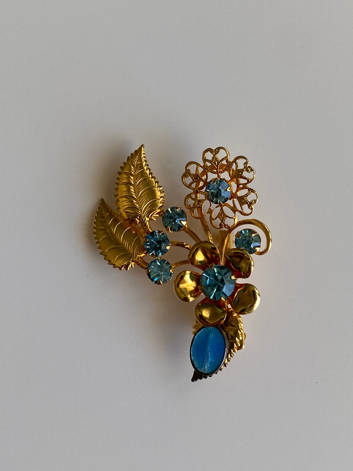 Vintage Gold Tone Blue Rhinestone Floral Spray Brooch with Cabochon Accent Pin Vintage Gold Tone Blue Rhinestone Floral Spray Brooch with Cabochon Accent Pin