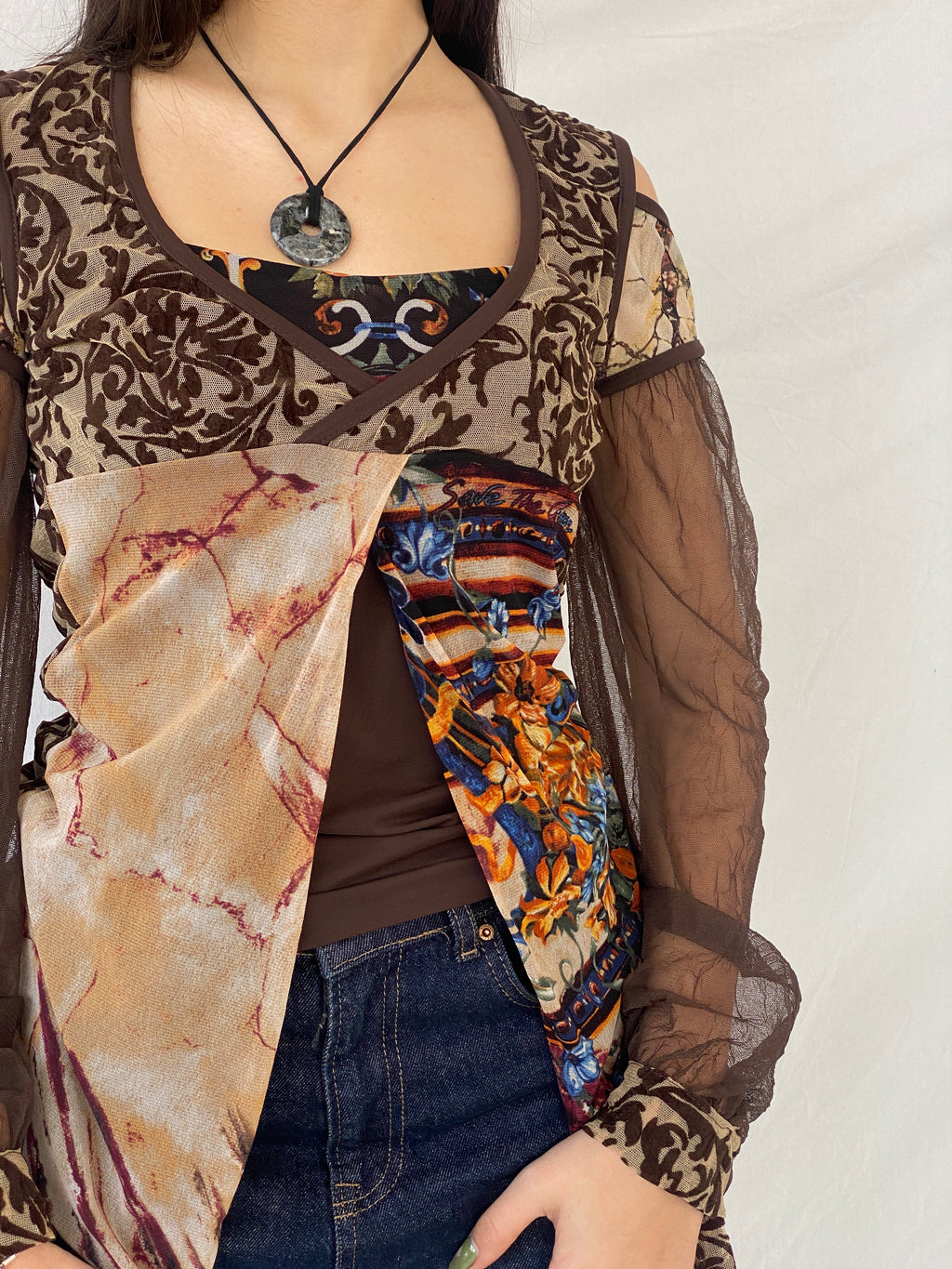 بلوزة "أنقذوا الملكة" بنية اللون بأكمام طويلة شفافة غير متماثلة - مقاس متوسط