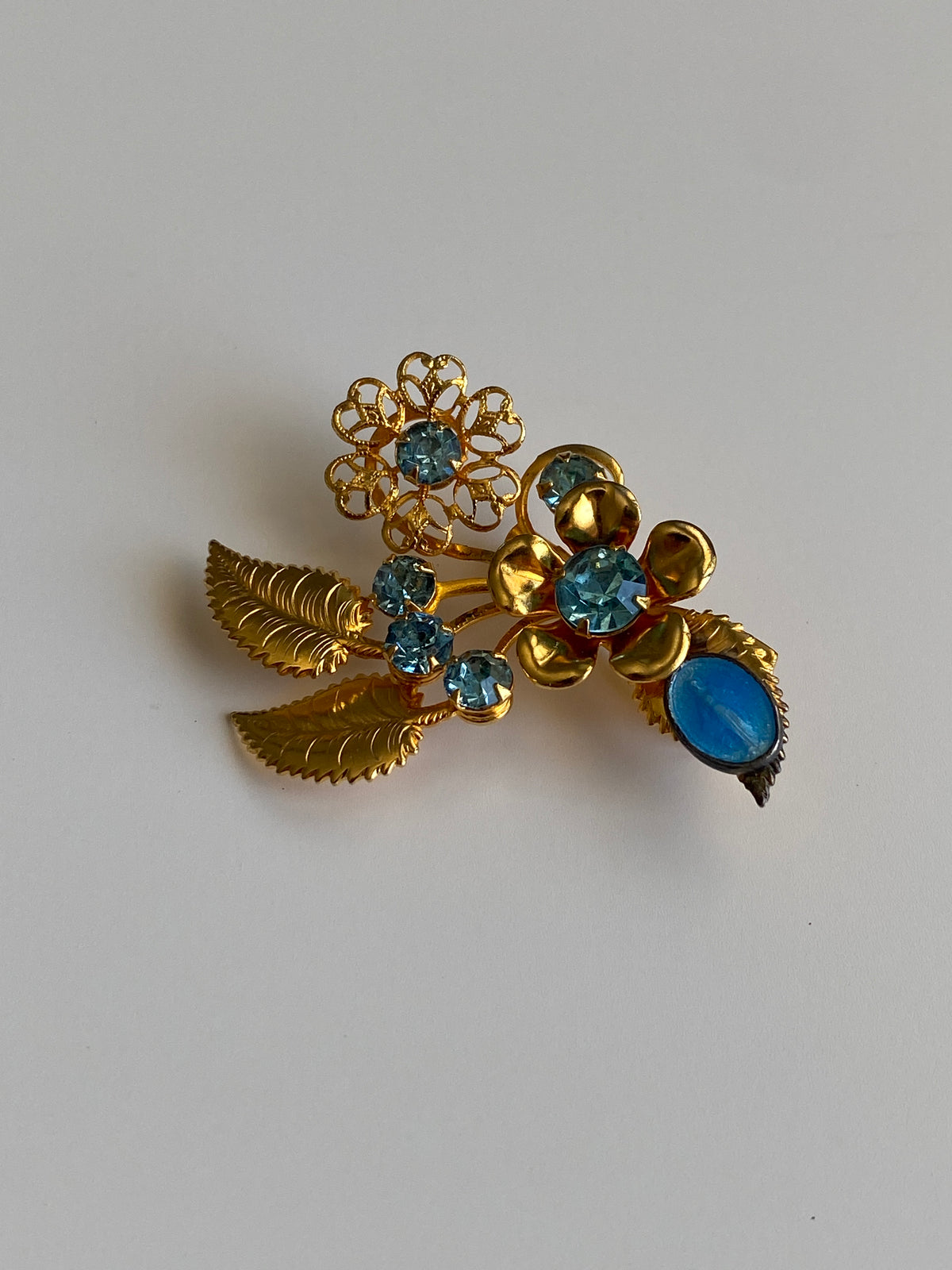 Vintage Gold Tone Blue Rhinestone Floral Spray Brooch with Cabochon Accent Pin Vintage Gold Tone Blue Rhinestone Floral Spray Brooch with Cabochon Accent Pin