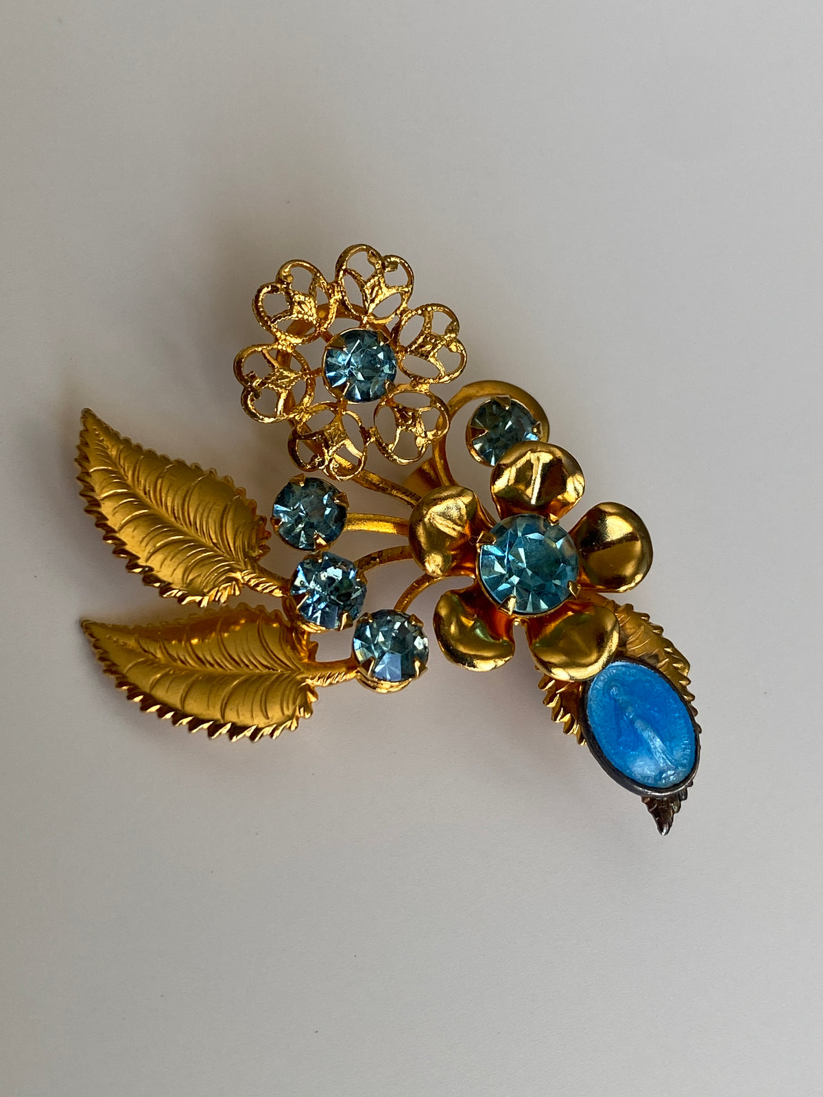 Vintage Gold Tone Blue Rhinestone Floral Spray Brooch with Cabochon Accent Pin Vintage Gold Tone Blue Rhinestone Floral Spray Brooch with Cabochon Accent Pin